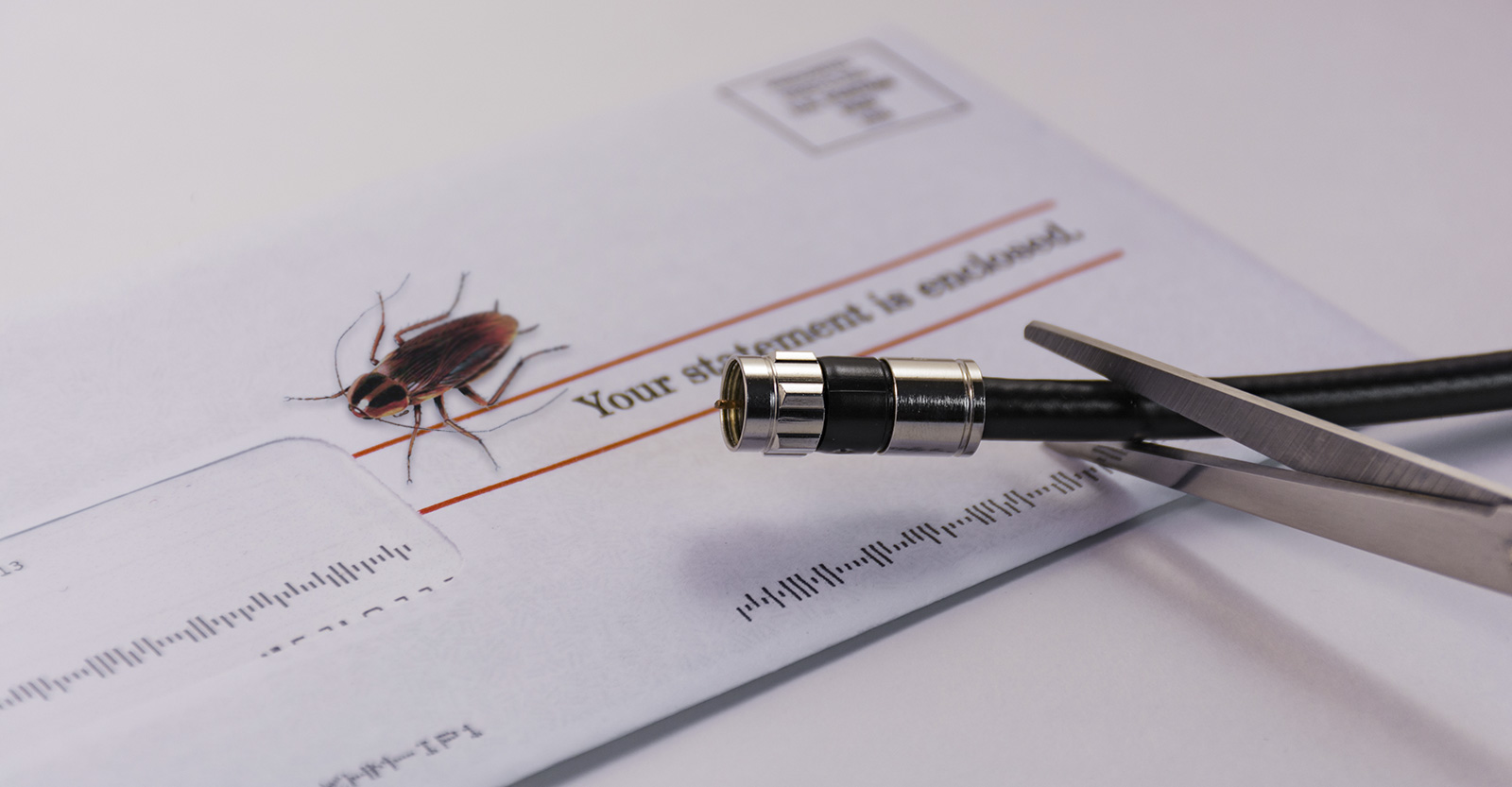 Scissors cutting cable cord. Roach on cable bill in the background.