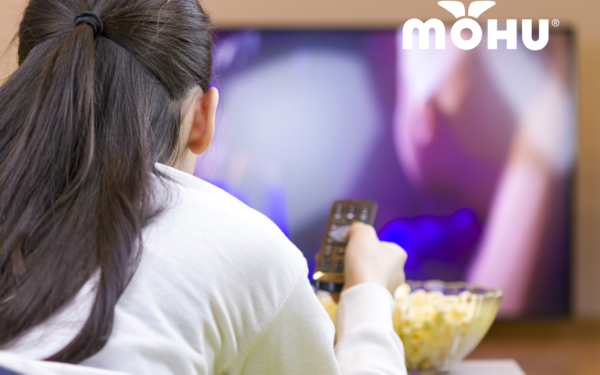 Girl watching TV with a bowl of popcorn and a mohu logo